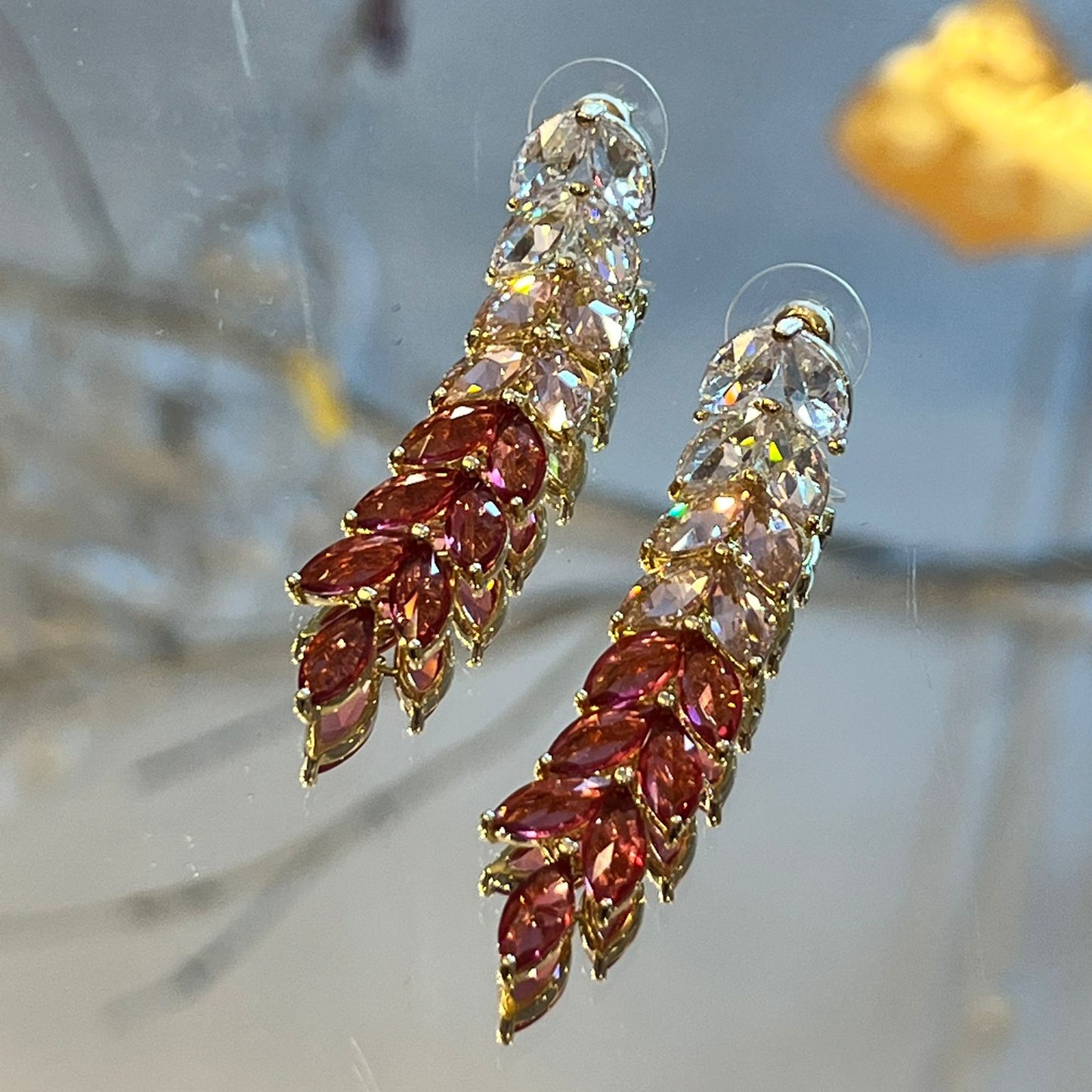 Pair of earrings with gemstones on a blurred natural background