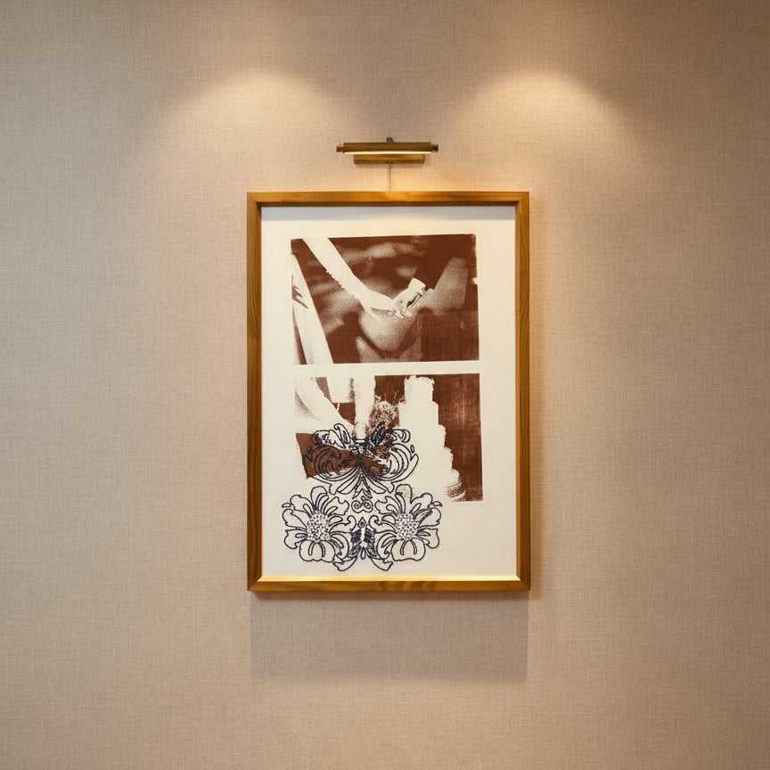 Framed artwork with a black and white photograph and decorative elements on a pink wall.