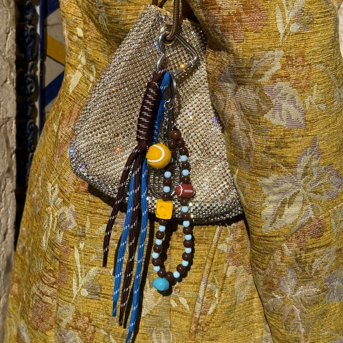 Decorative beaded bag with colorful strings on a textured fabric background