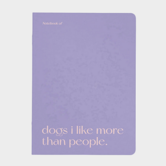 Purple notebook with text 'dogs i like more than people.' on a light gray background