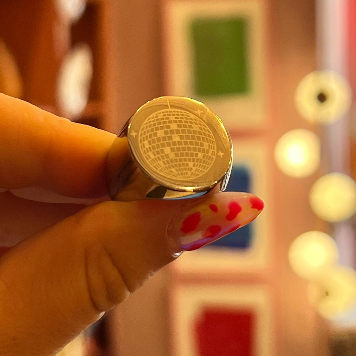 Close-up of a hand holding a ring with a textured surface against a blurred background.