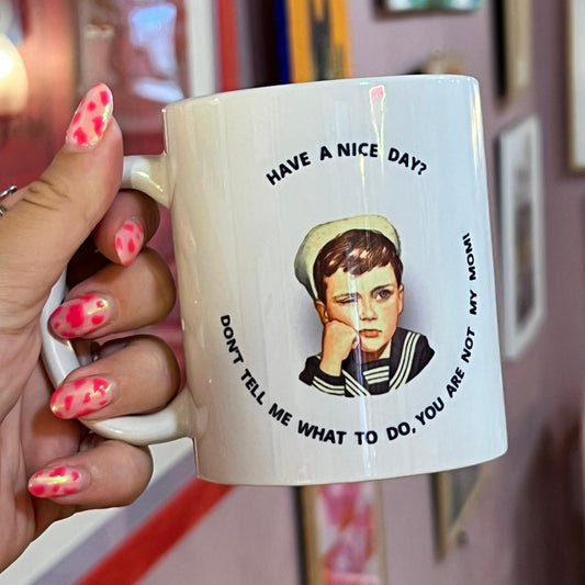 Mug with a design and text held by a hand in a casual setting