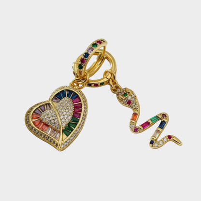 Gold earring with heart and snake design on a white background